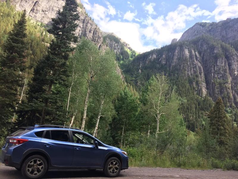 Sapphire parked before some audacious mountains and grand old trees